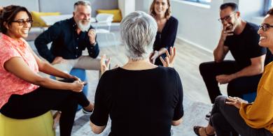 
		Eine Gruppe von Menschen diskutiert im Sitzkreis
	