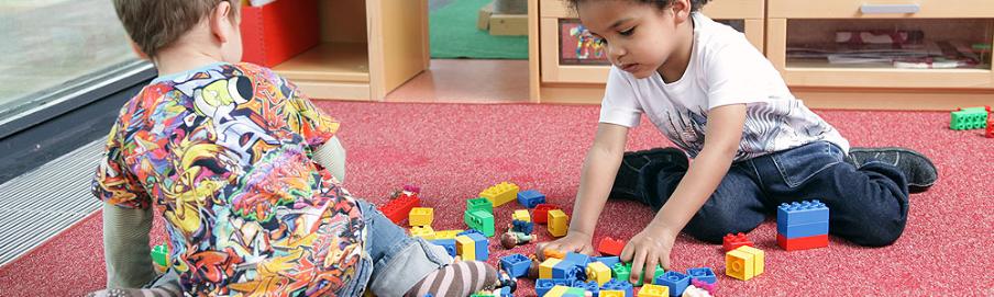 Kinder spielen auf dem Boden