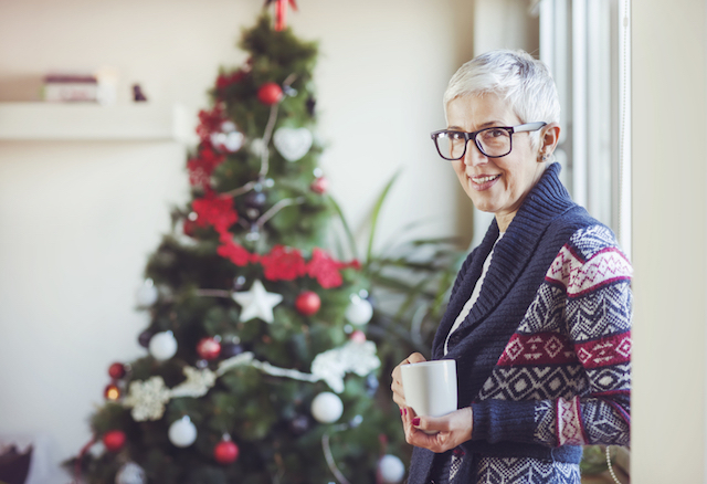 Eine Frau alleine untern Weihnachtsbaum