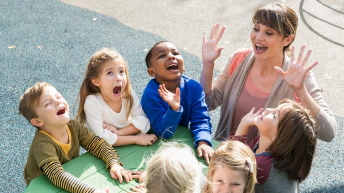 Erzieherin mit Kindern an einem Tisch