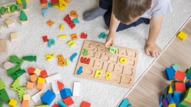 Kind spielt mit bunten Buchstaben
