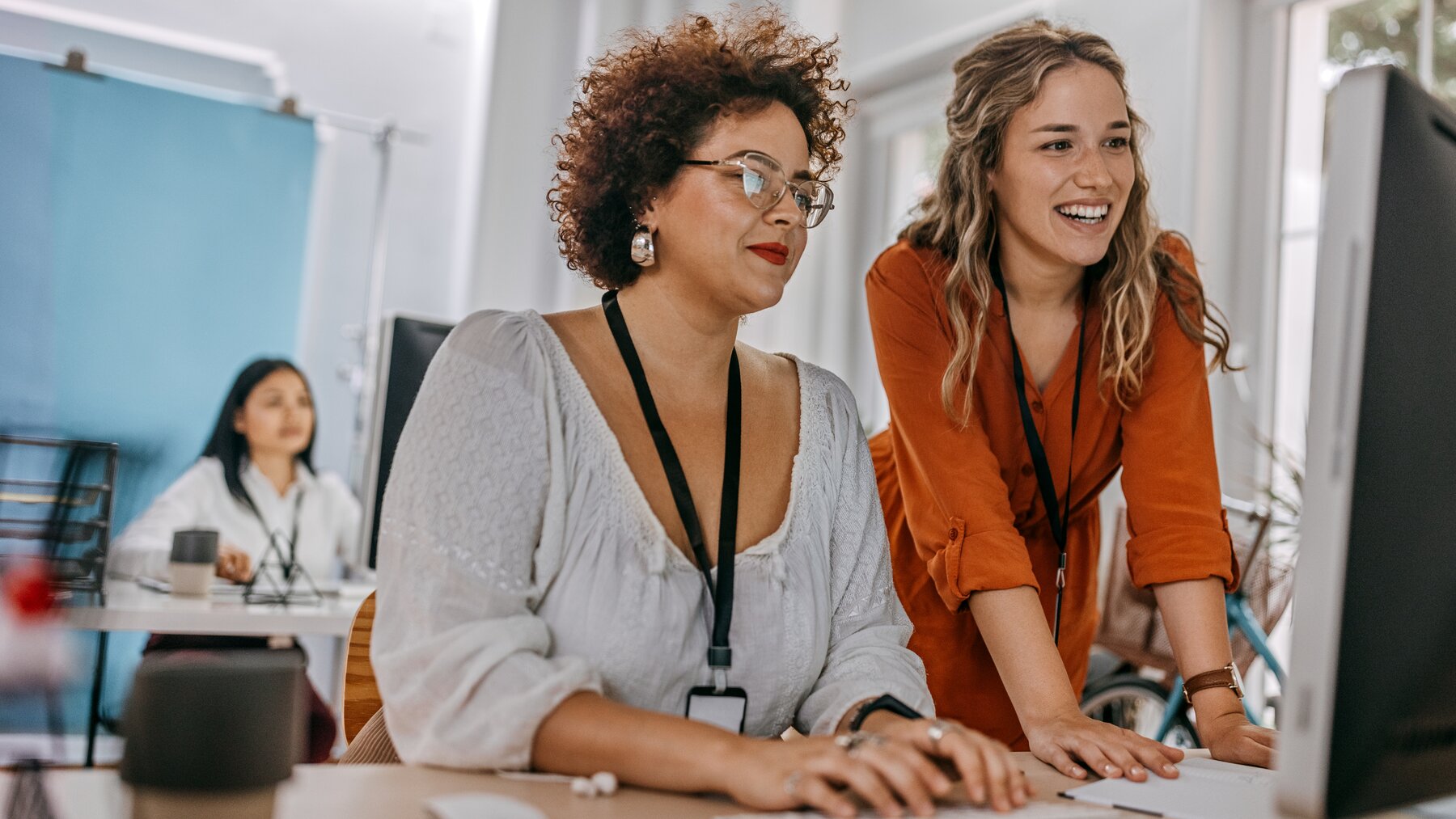 zwei Frauen unterschiedliches Alter arbeitem am Desktop