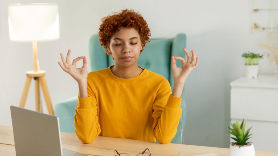 Frau am Schreibtisch macht Yoga